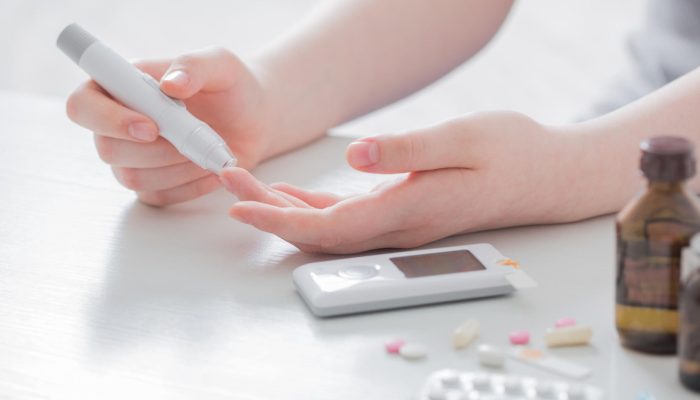 girl teenager measures blood sugar level