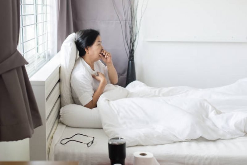 Elderly asian woman coughing and sitting on her bed,Concept of health