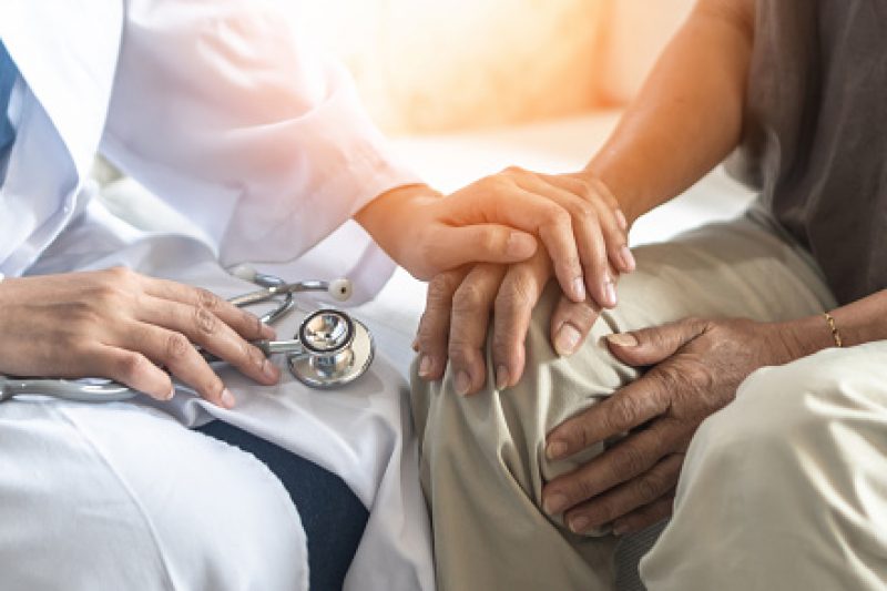 Parkinson's disease patient, Arthritis hand and knee pain or mental health care concept with geriatric doctor consulting examining elderly senior aged adult in medical exam clinic or hospital